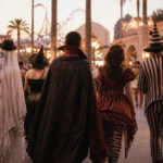 A vibrant scene from Halloween Horror Nights featuring scareactors and themed decorations.