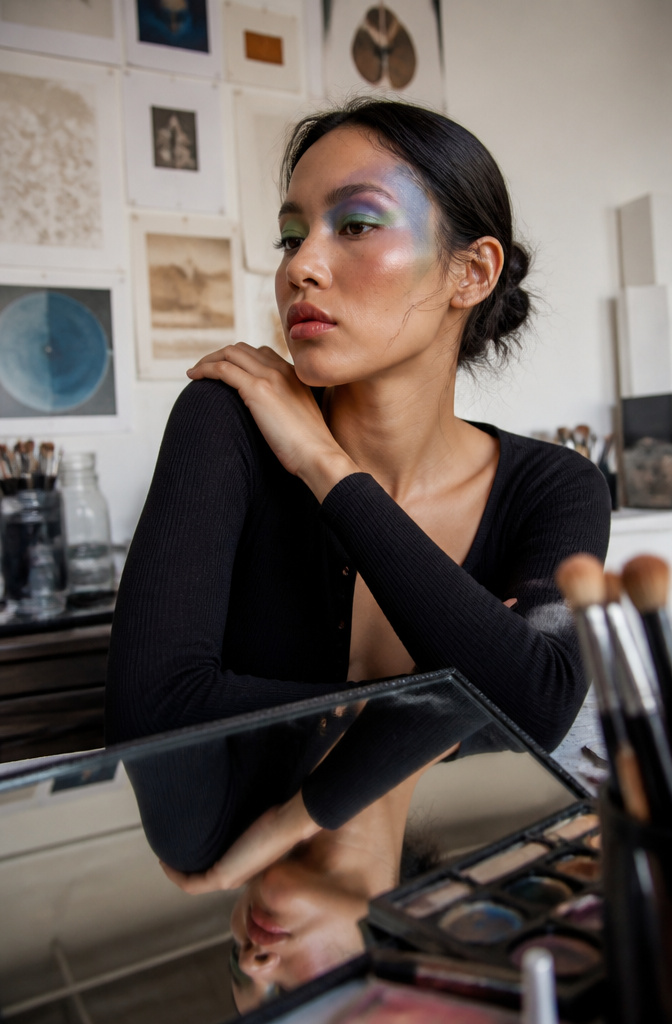A model showcasing a bold editorial makeup look with creative textures.