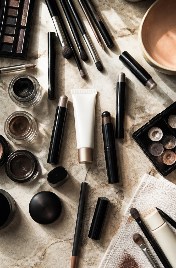 How to Do a Smokey Eye: A 9-Step Tutorial for 2026 13 Makeup products including Revlon primer and cream shadow sticks on display.