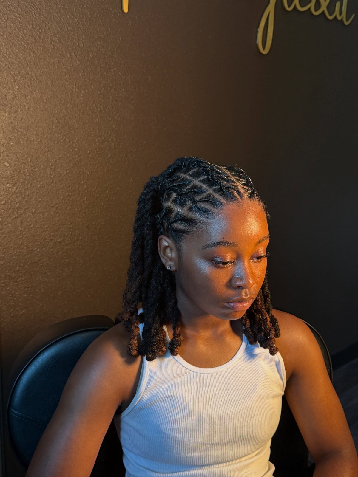 Woman with black hair styled in cornrows transitioning into locs.