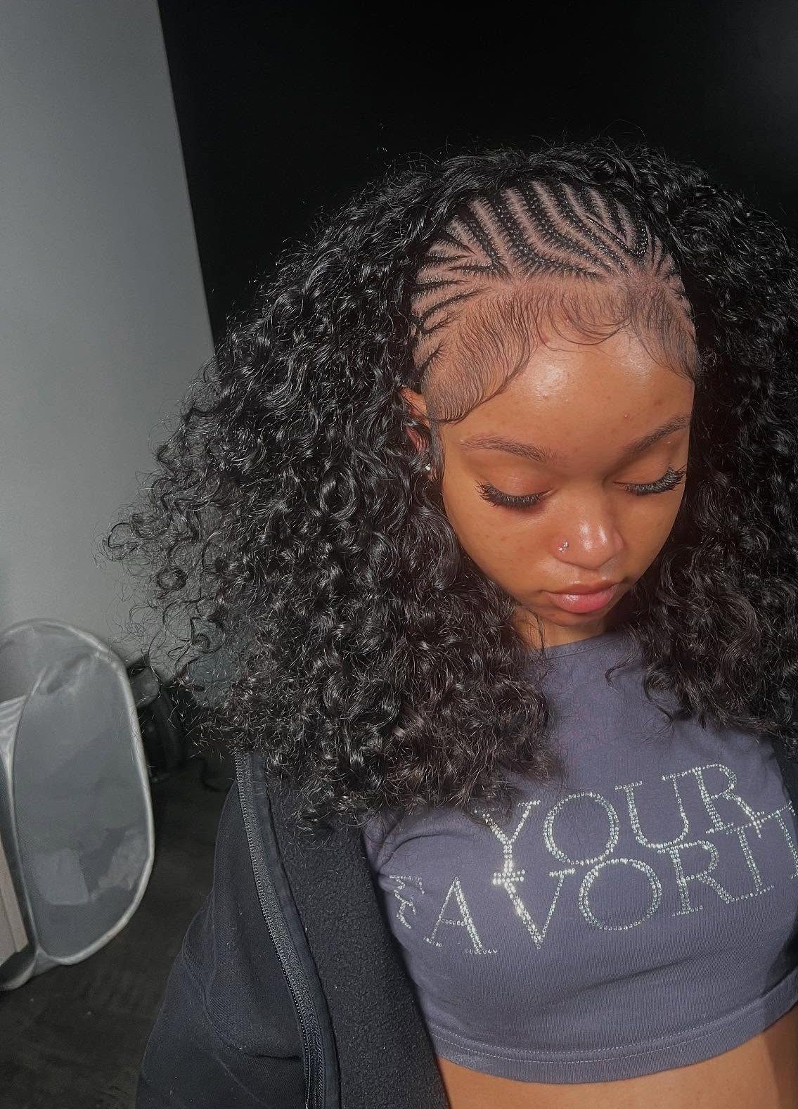 Woman with a hairstyle combining small cornrow braids and voluminous curly hair.
